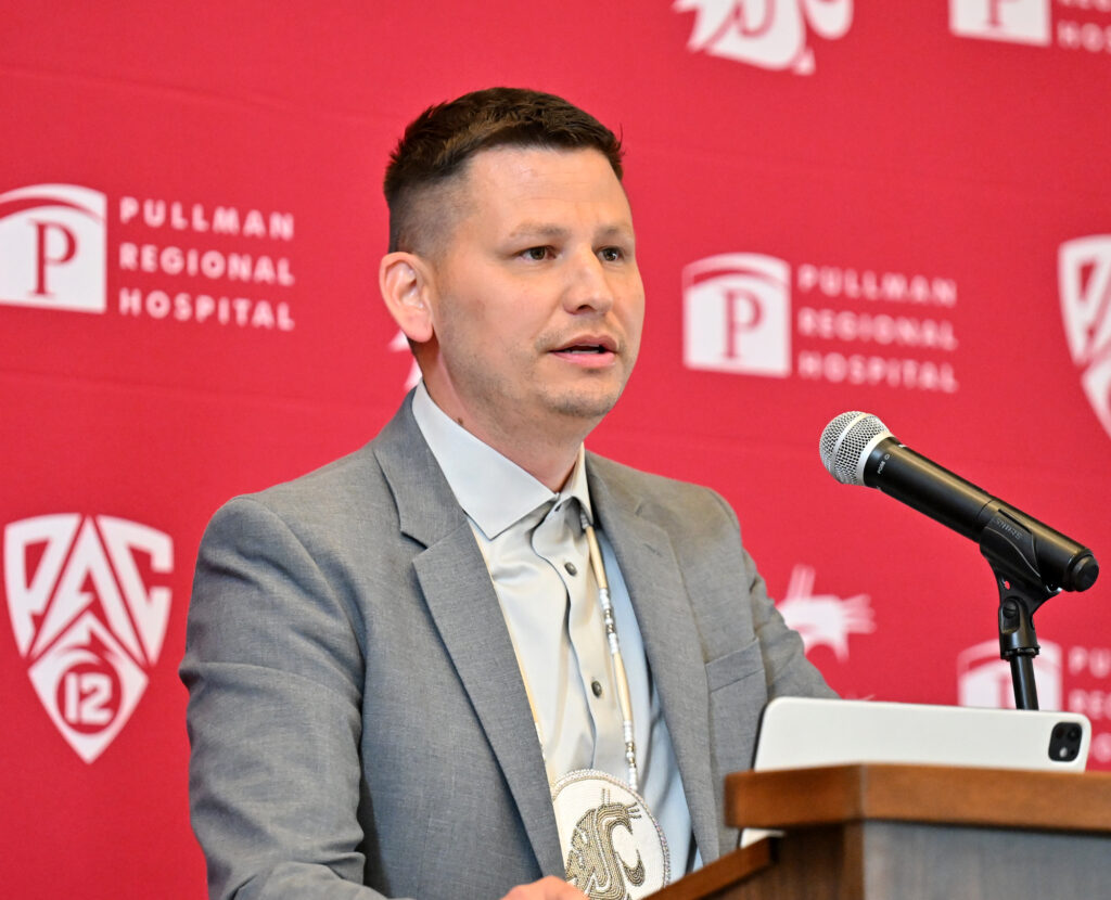 Closeup of Jarred-Michael Erickson addressing a crowd from a podium.