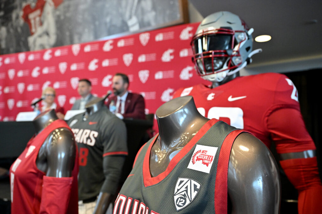 Closeup of mannequins featuring WSU athletic uniforms with a Colville Tribe jersey patch.
