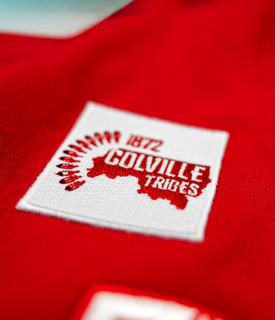 Closeup of a Colville Tribe jersey patch on a crimson WSU uniform.