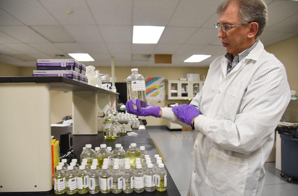 The director of USTUR holds an acid-digested tissue sample in a research lab.