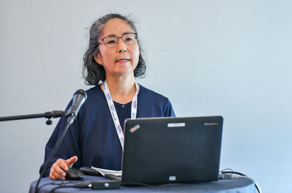 Professor speaks at a lectern during a conference