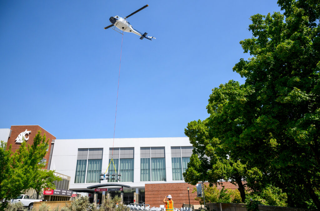 A helicopter rises from outside Gesa Field as it prepares to deliver a new LED light fixture.