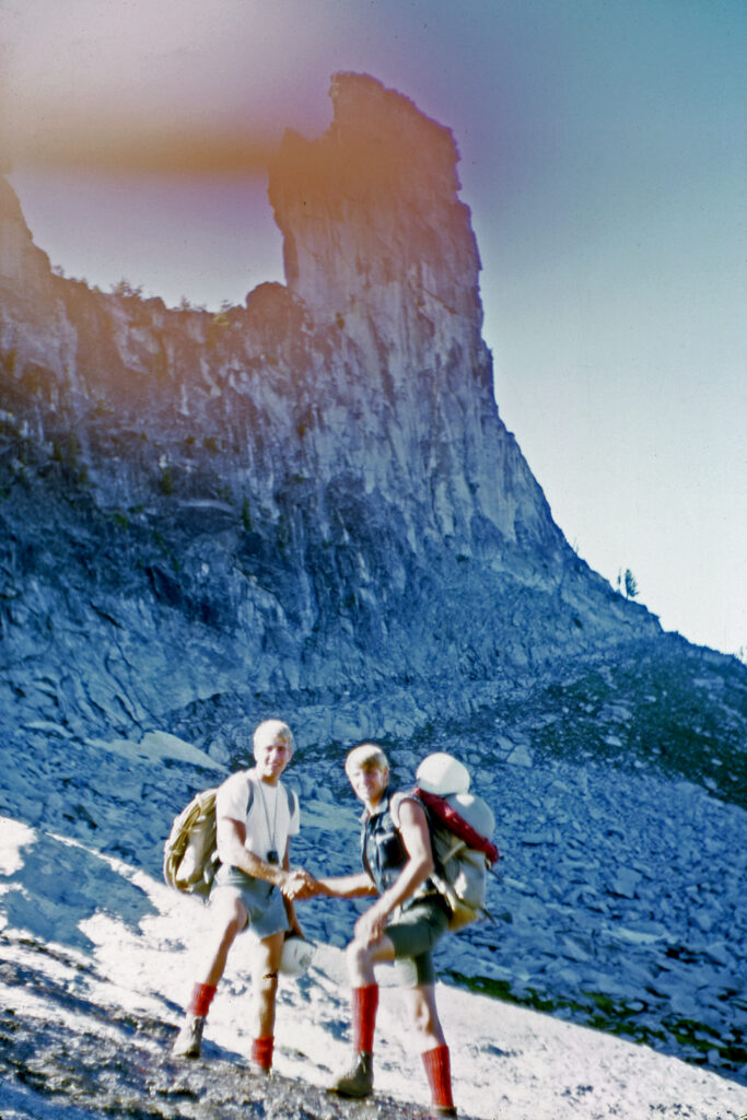 Two climbers stand in front of the east face of Idaho's Chimney Rock in 1967.