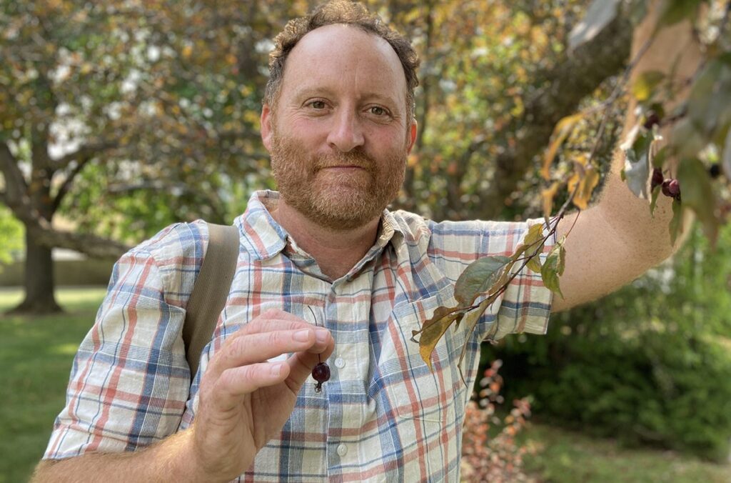 Horticulture professor poses with tree fruit