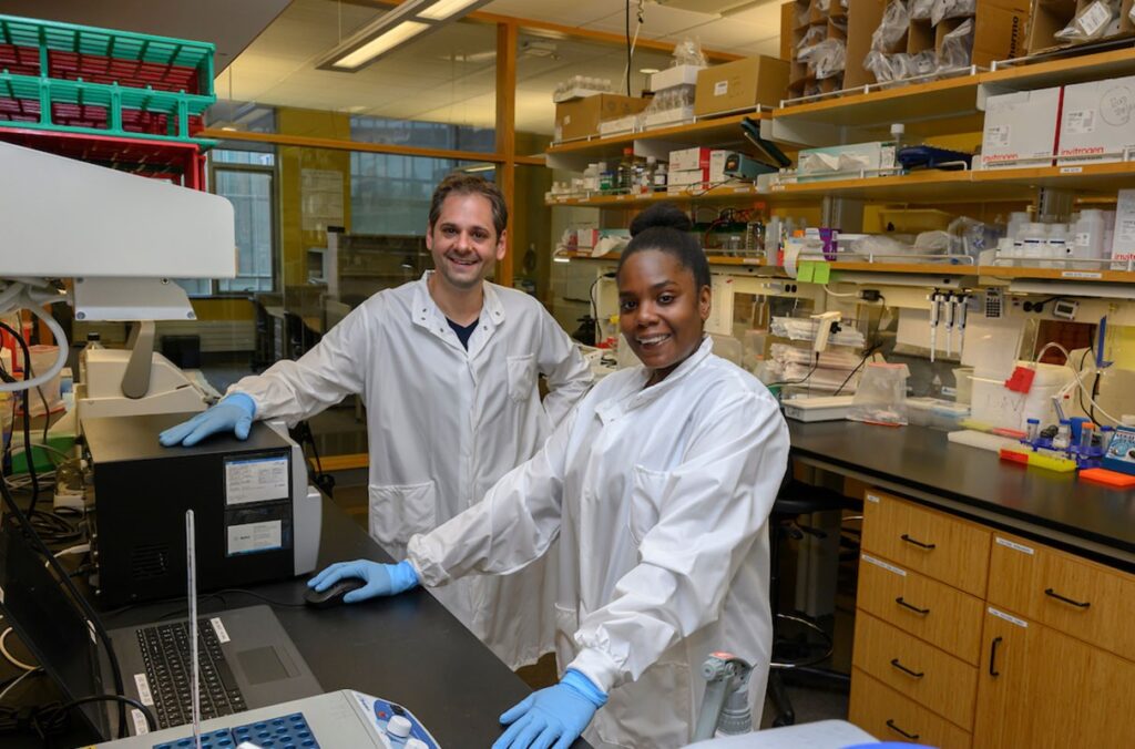 Two researchers pose in their laboratory.