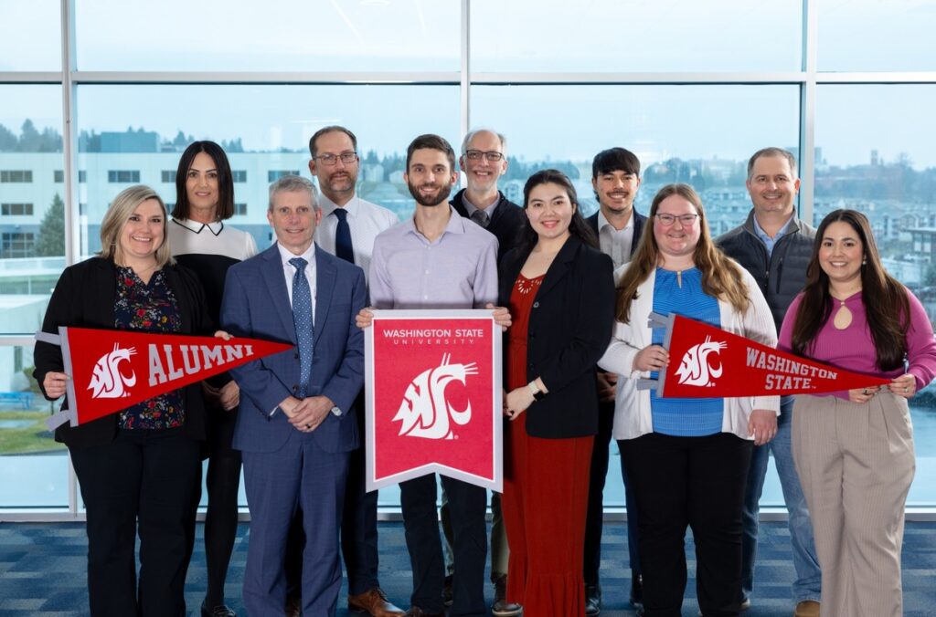 A mixed group of WSU alumni hold WSU banners at SEL.