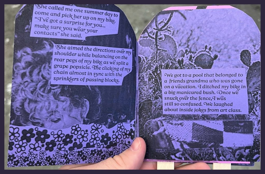 A hand holds open a purple-and-black illustrated booklet with popsicle-stick handles, featuring text and artwork depicting a childhood summer memory.