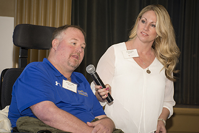 Assisted by his wife Theresa, Matt Wild talks about life with ALS during the symposium’s clinical problems discussion panel.