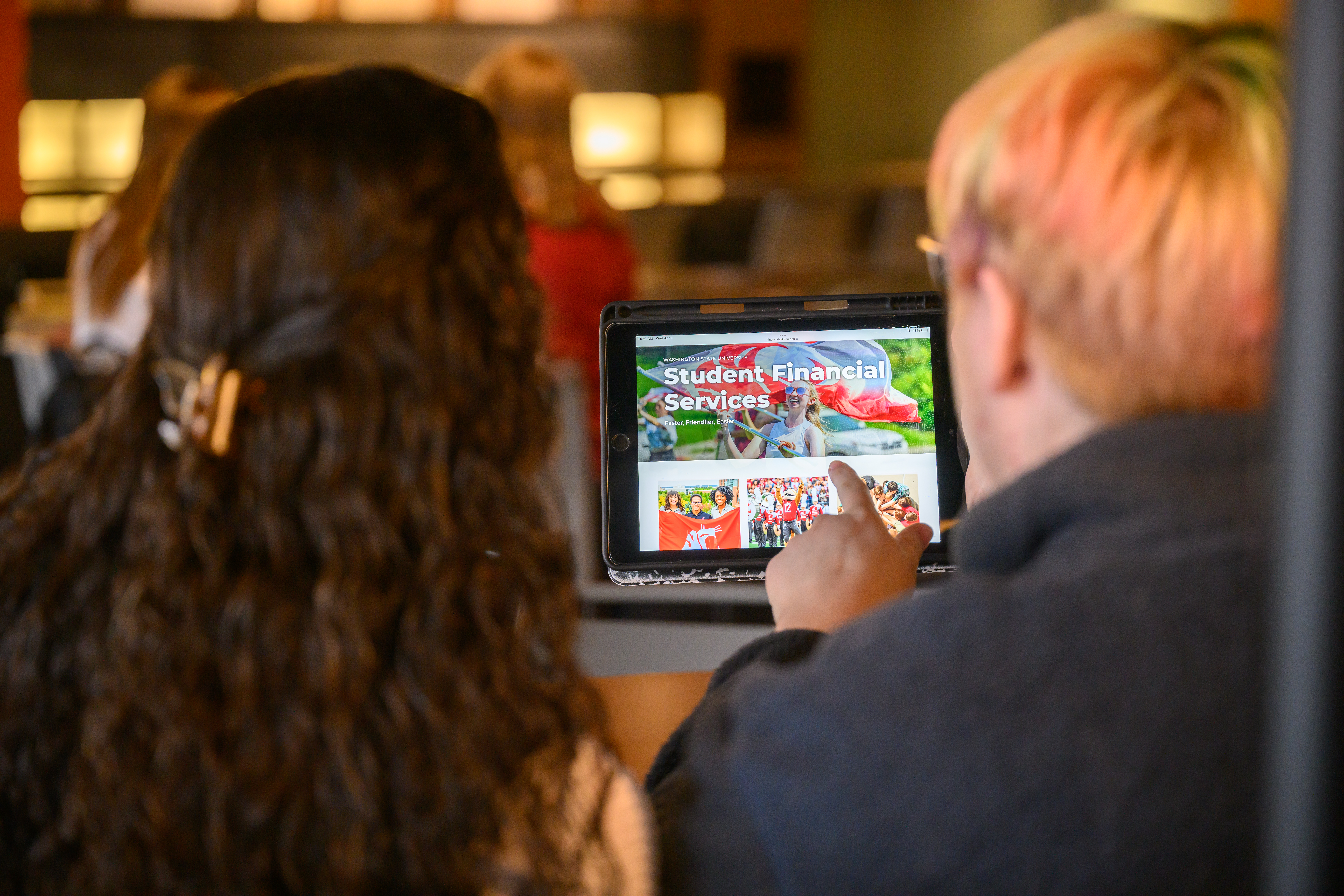 Two students browsing the WSU Student Financial Services website.