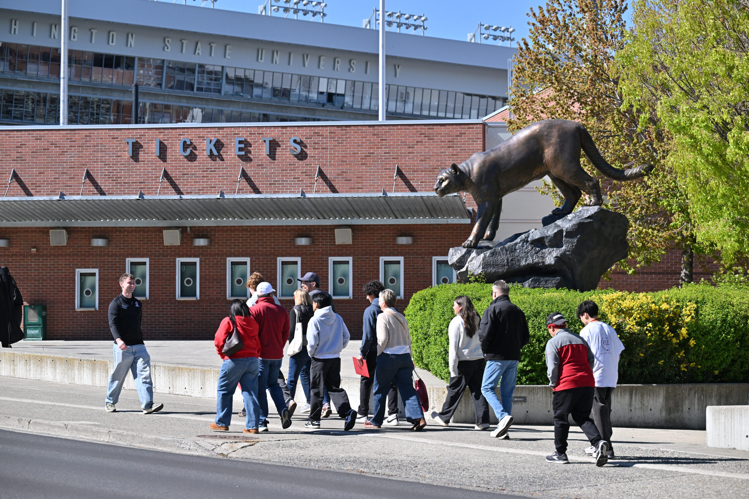 Prospective students walk in front of the Cougar Pride statue as part of Campus Tour