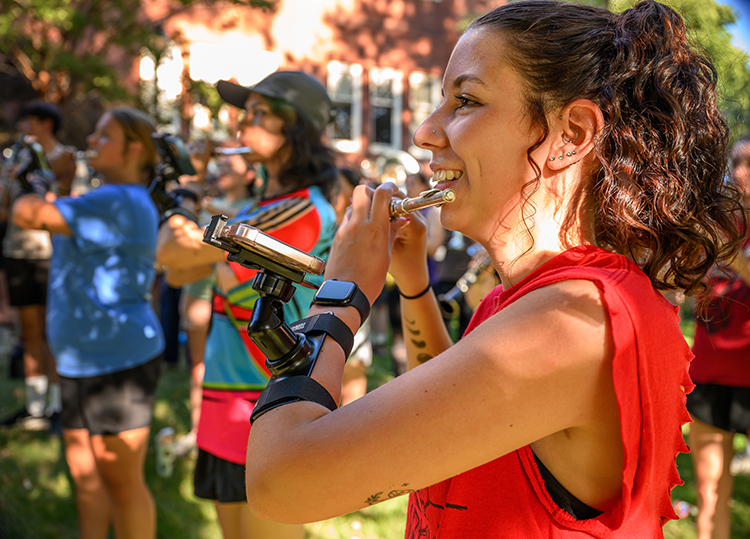 A student smiles about to play the flute at band camp.