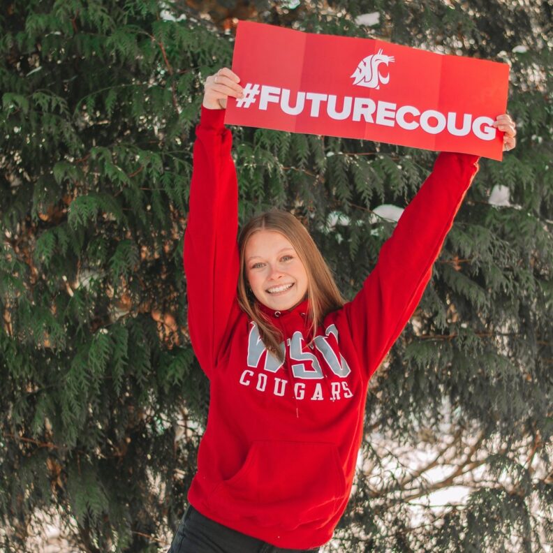 Young student holding #FutureCoug poster.