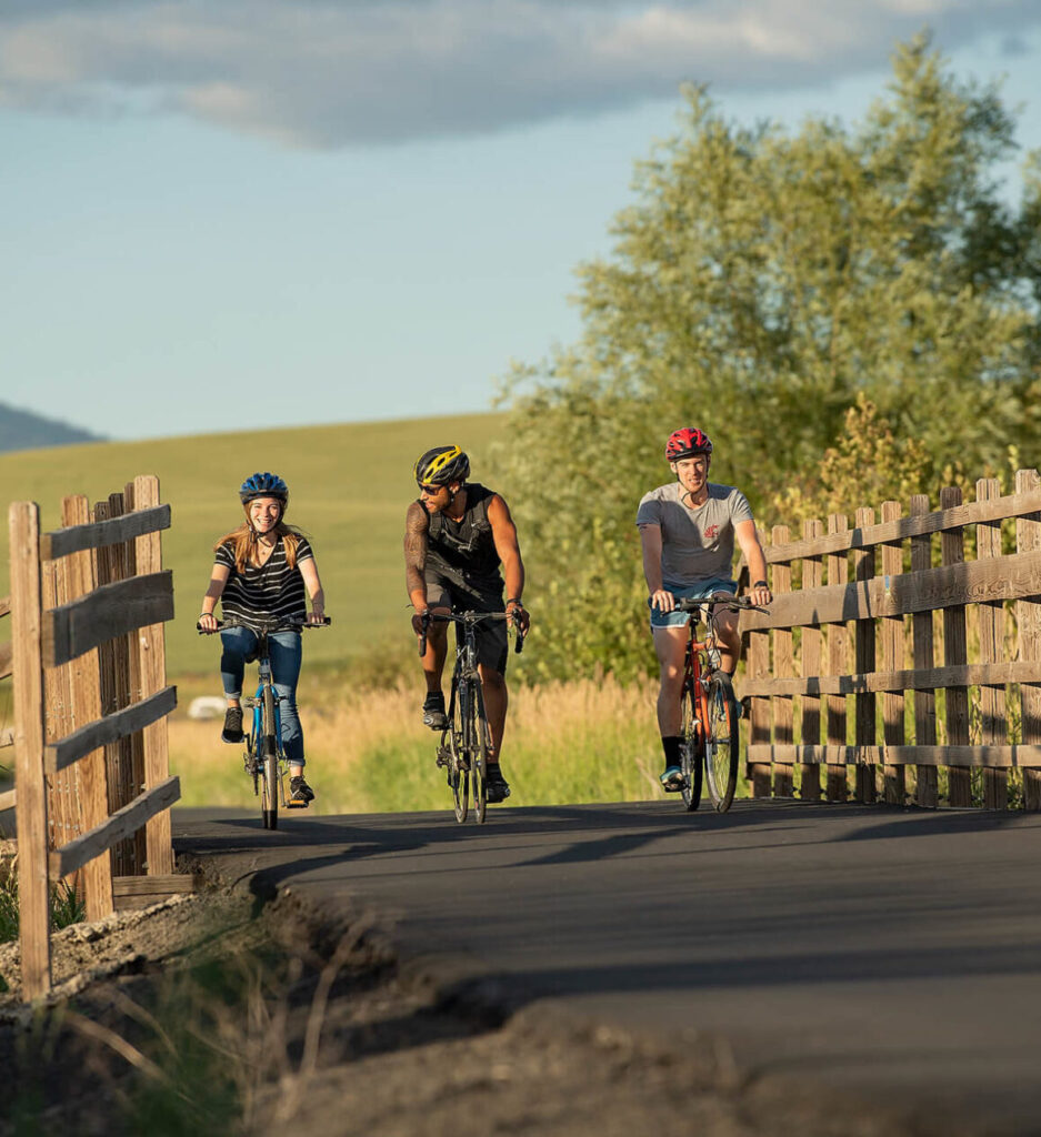 Three bikers riding on a bike path. 