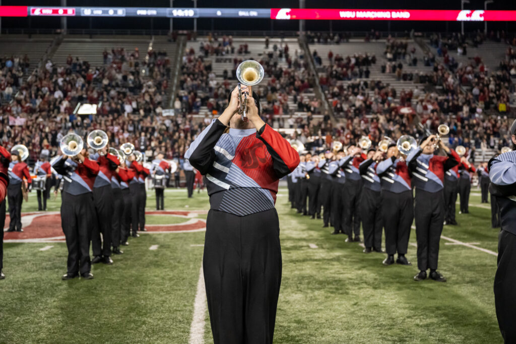 University band member playing a trumpet on the football field.