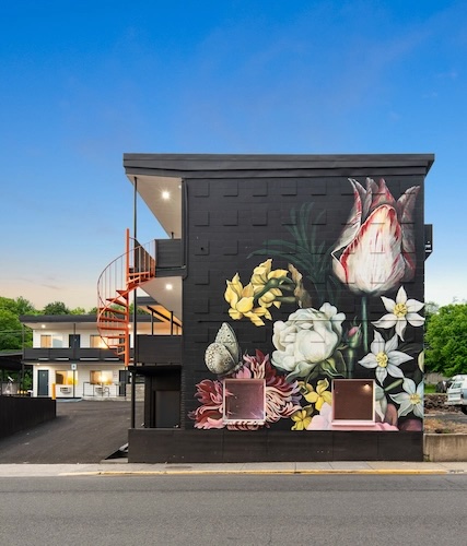 A mural painted on the side wall of a motel.