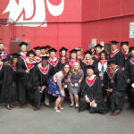 Thumbnail of http://Large%20group%20of%20graduates%20in%20black%20caps%20and%20gowns%20posing%20together%20in%20front%20of%20a%20red%20wall%20with%20the%20Washington%20State%20University%20logo.