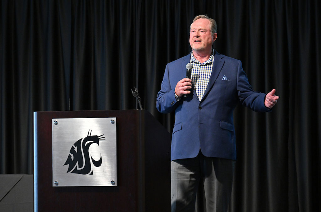 Dan Lynch speaks on stage beside a WSU podium, holding a microphone during an entrepreneurship event.