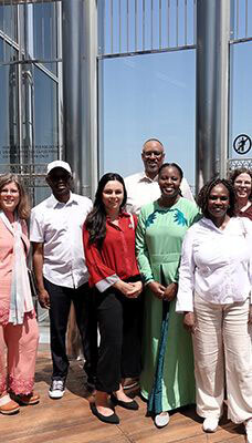 A group of people standing together in front of a glass and metal structure, which appears to be part of the Burj Khalifa in Dubai.