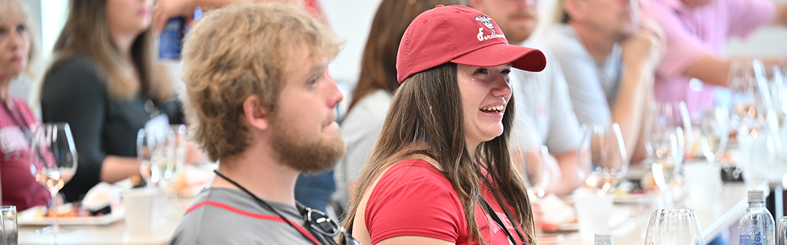People seated at tables participating in a beverage‑tasting hospitality event.