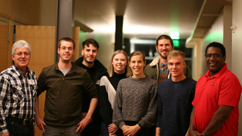 Carson College Vancouver students with MAP client Peter Clarke and MAP mentor Ken Torre standing together in a hallway during spring 2020.
