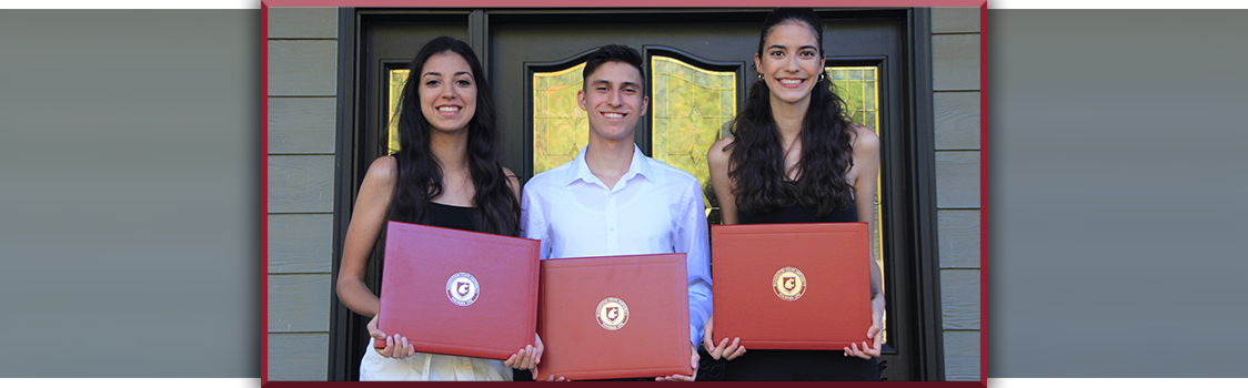 Kristen, Michael, and Kathryn Saba stand holding their red WSU diploma covers, celebrating as third‑generation Cougar graduates.