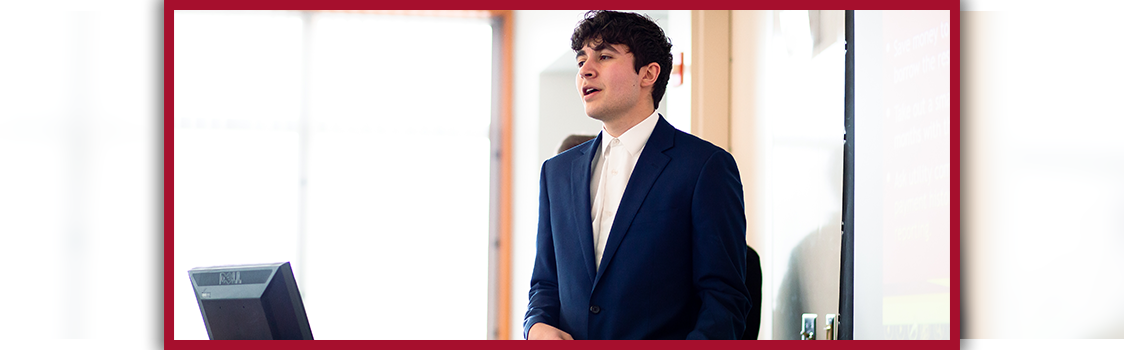 Dominic Hernandez standing beside a lectern and projection screen while speaking to a class.