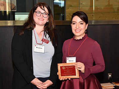 Shirin Shahsavand, at right, holding her teaching excellence award plaque while standing beside Reanne Cunningham Chilton at the event.