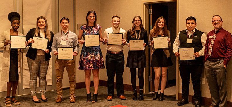 Accounting scholarship winners standing in a row holding certificates at the spring banquet, with Benjamin Warren at the far right.