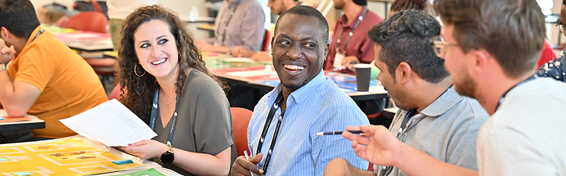 WESKA participants sit together at a table reviewing worksheets and discussing ideas as they collaborate on a group project.