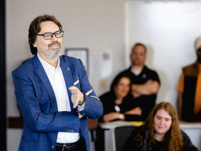 Professor Joe Compeau speaks during the ceremony recognizing those involved in his life‑saving emergency response.