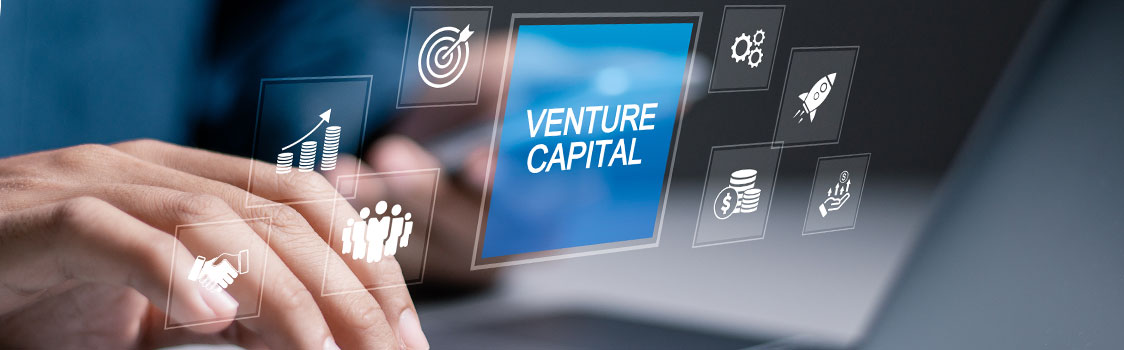 Hands typing on a laptop with floating digital icons related to business—growth charts, teamwork, funding, and a highlighted ‘Venture Capital’ panel.