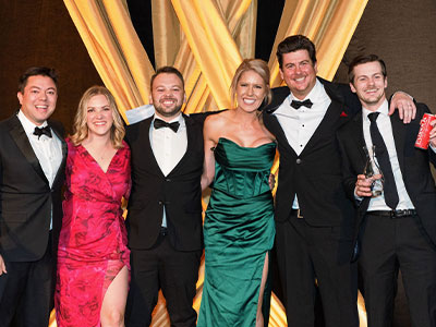 Paddock team in formal attire posing at the San Francisco World Spirits Competition, marking best‑in‑class and double‑gold wins for canned cocktails.