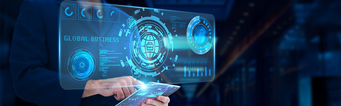 A person uses a tablet to interact with a glowing blue holographic interface displaying global business graphics and futuristic digital controls.