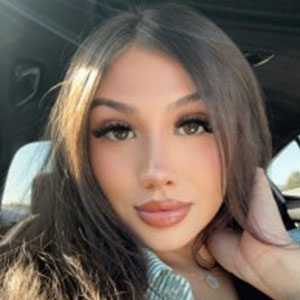 Katrina Mendez seated in a car with long brown hair and sunlight streaming in from the side window.