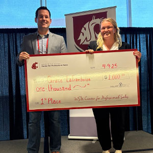 Grace LaFramboise and another individual holding a large $1,000 check for 1st place from the WSU Center for Professional Sales.