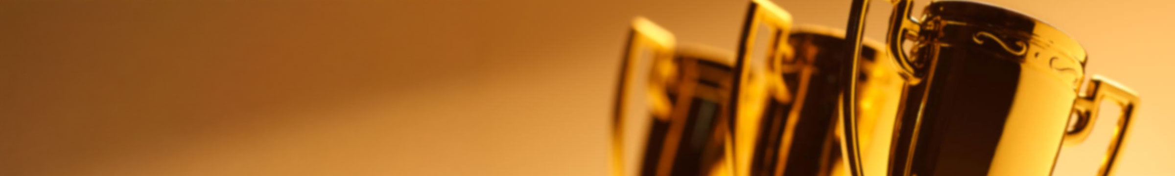 Golden trophies on a warm, amber background.