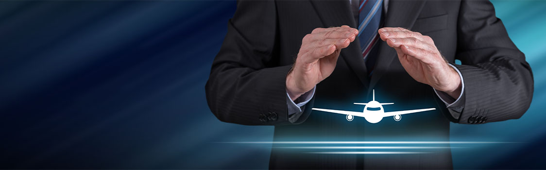 Person in a suit holding their hands above a glowing airplane icon, suggesting protection or support, set against a blue motion‑blur background.