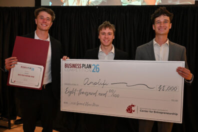 Amplifi team members hold an $8,000 award check and Best Tech Venture certificate at the Business Plan Competition.