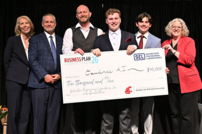 Opulence AI team members receive a $10,000 first-place award check at the Business Plan Competition banquet.