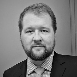 Grayscale headshot of Adam Peterson.