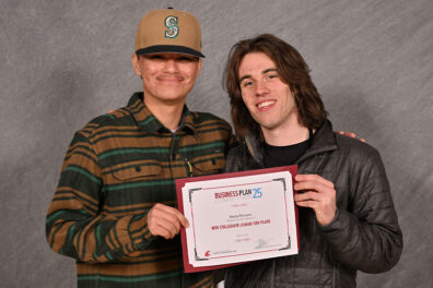 Antonio Casila (left) in a striped shirt and cap, and Anthony Devito (right) in a dark jacket, holding a certificate for fifth place in the Business Plan 25 WSU Collegiate League.