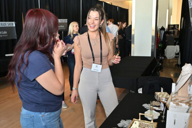 MJ Kunkle of Wearable Aromas speaks with an attendee at the BPC Trade Show.