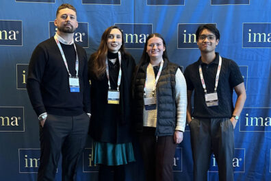 Four Carson College accounting students standing in front of a blue IMA-branded backdrop at the IMA Student Leadership Conference in Cleveland, Ohio.