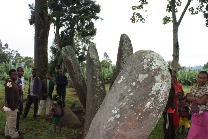 People standing next to large stones