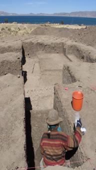 Person standing in archaeological dig somewhat deep in the ground.