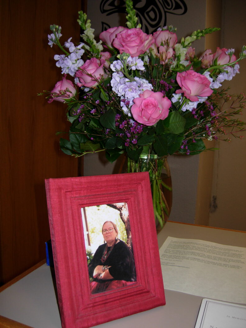 Framed photo of Nancy McKee with flowers at her memorial in the Anthropology Museum