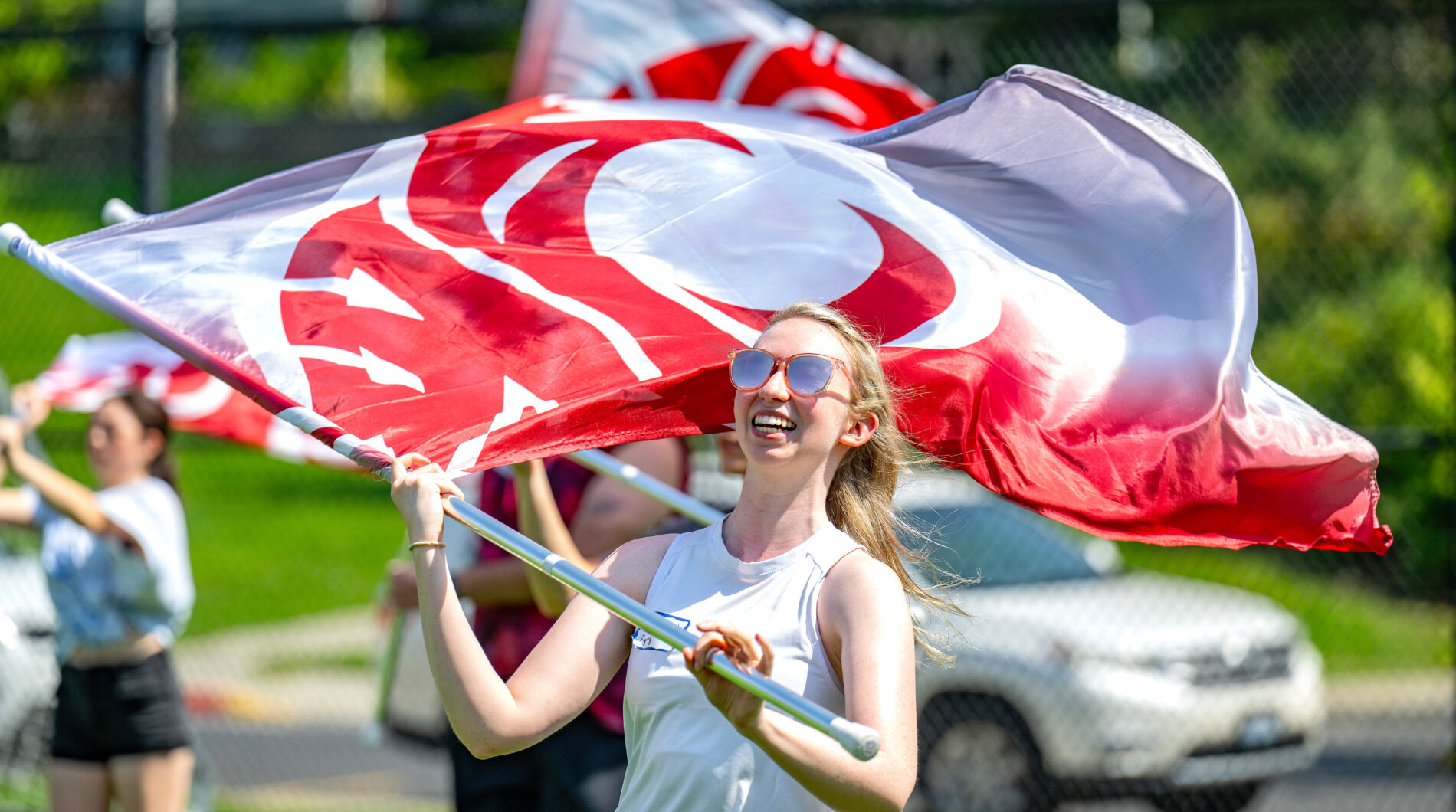 WSU color guard member twirling flag at practice