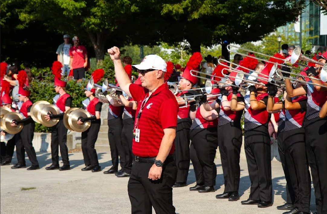Cougar Marching Band director leading members in warmup outside