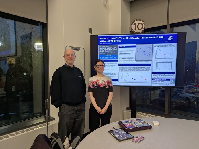 A faculty mentor and student pose beside a research poster