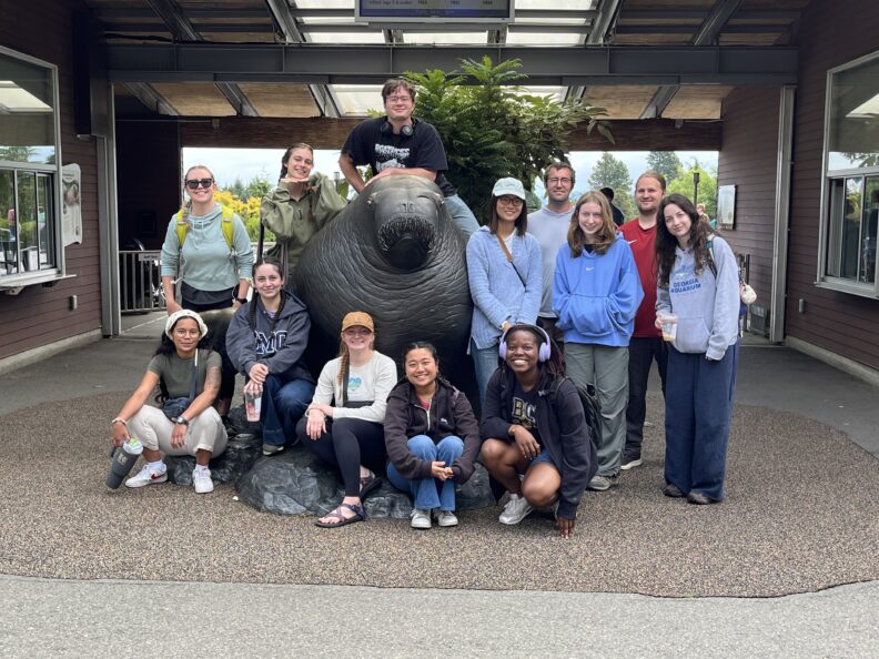 2025 Cohort at the Point Defiance Zoo: front r-l: Tammi Morellano, Sofia Yildirim, Jessica Matthew, Ana Rowley, Tamia Love. Back r-l: Grace Curtis (R&R REU Assistant Director), Adel Bordas, Chris Close, Jing Grader, Nick Kessler, Nina Allen, Tyler Robinson, Ruby Moore (missing: Thomas Holloway).